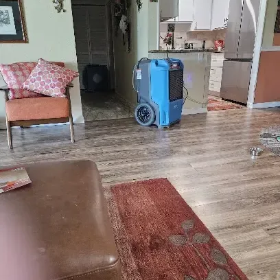 Dehumidifier drying a living room after a leak